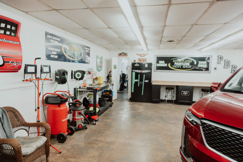 Inside Heartland Dent Shop in Tulsa with pointless dent repair lighting, equipment and shop signage.